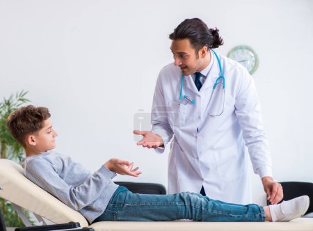 Photo for The young male doctor pediatrist and boy in wheel-chair - Royalty Free Image