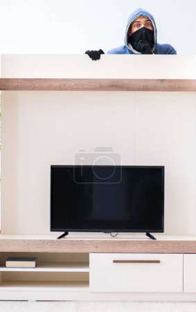 Photo for The man burglar stealing tv set from house - Royalty Free Image