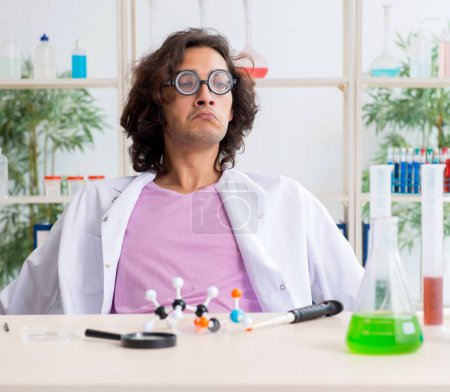 Foto de El gracioso químico masculino que trabaja en el laboratorio - Imagen libre de derechos