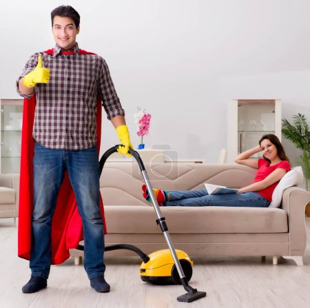 Foto de El marido superhéroe ayudando a su esposa en casa - Imagen libre de derechos