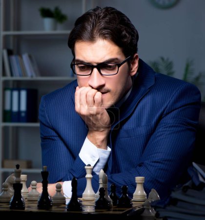 Foto de El hombre de negocios jugando al ajedrez en concepto de estrategia - Imagen libre de derechos