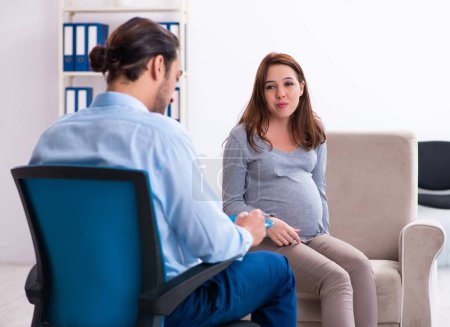 Téléchargez les photos : Femme enceinte rendant visite à un jeune psychologue - en image libre de droit