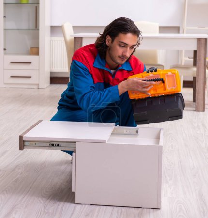 Foto de Joven carpintero trabajando ensamblando muebles - Imagen libre de derechos