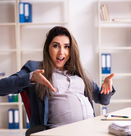 Photo for The young pregnant woman working in the office - Royalty Free Image