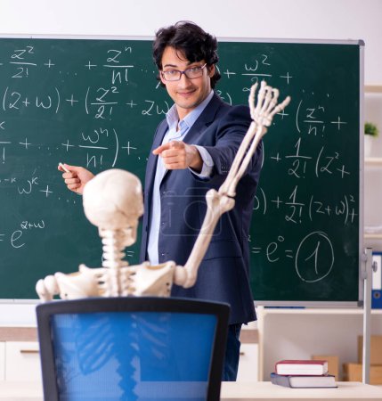 Foto de El joven profesor de matemáticas masculino y el esqueleto del estudiante - Imagen libre de derechos