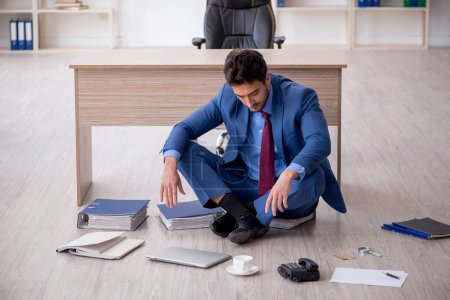 Téléchargez les photos : Young employee unhappy with excessive work at workplace - en image libre de droit
