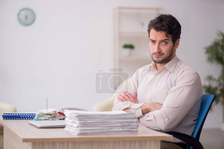 Téléchargez les photos : Young accountant sitting at workplace - en image libre de droit