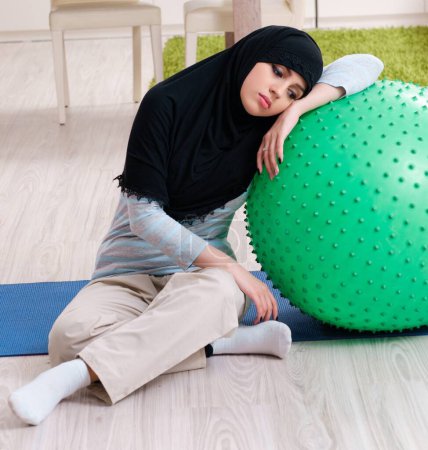 Foto de La joven en hiyab haciendo ejercicios en casa - Imagen libre de derechos