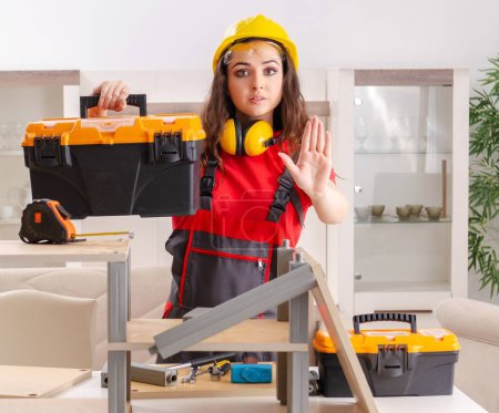 Téléchargez les photos : The female contractor repairing furniture at home - en image libre de droit