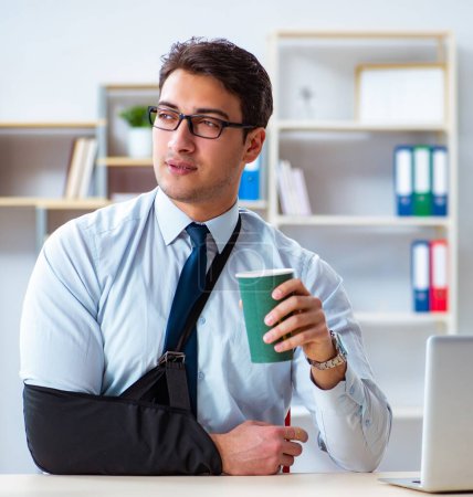Téléchargez les photos : L'homme d'affaires avec le bras cassé travaillant dans le bureau - en image libre de droit