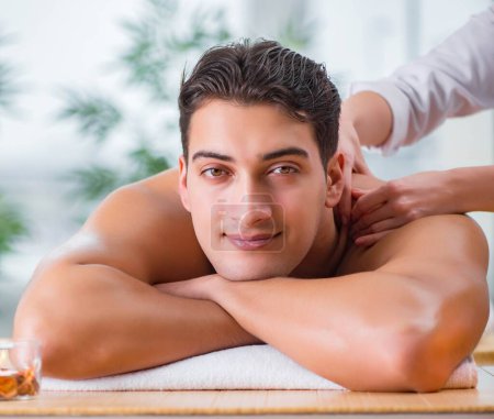 Téléchargez les photos : Le bel homme pendant la séance de massage spa - en image libre de droit