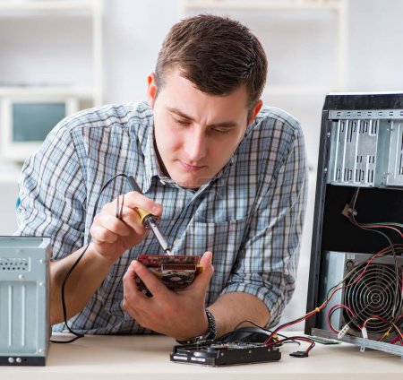 Photo for The young technician repairing computer in workshop - Royalty Free Image