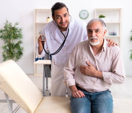 Photo for Old man visiting young doctor cardiologist - Royalty Free Image