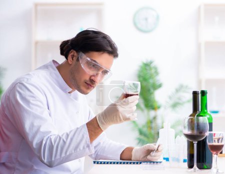 Téléchargez les photos : Le chimiste qui examine les échantillons de vin au laboratoire - en image libre de droit
