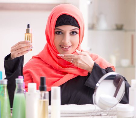 Foto de La hermosa mujer en hiyab aplicando maquillaje - Imagen libre de derechos