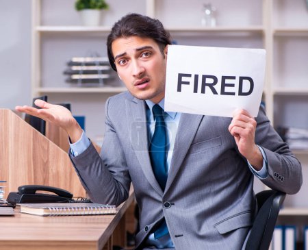 Téléchargez les photos : Le jeune employé masculin licencié de son travail - en image libre de droit