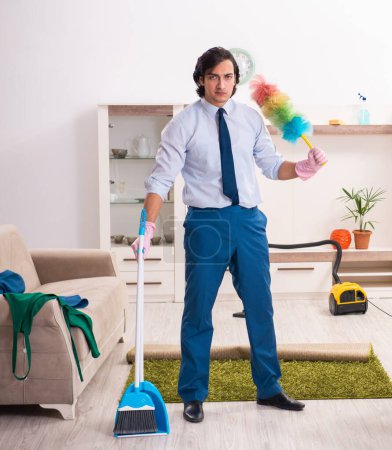Foto de El joven empresario limpiando la casa - Imagen libre de derechos