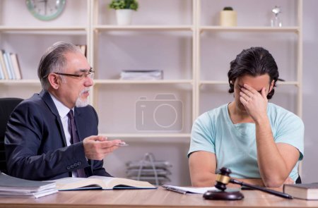 Photo for The young man visiting experienced male lawyer - Royalty Free Image