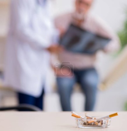 Photo for Young doctor and old patient in antismoking concept - Royalty Free Image