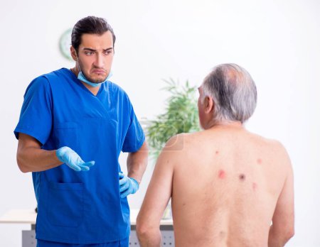Téléchargez les photos : Vieil homme visitant le médecin dermatologue masculin - en image libre de droit