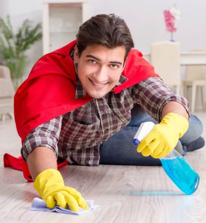 Téléchargez les photos : Le super héros mari nettoyage plancher à la maison - en image libre de droit