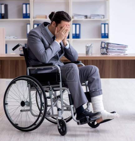 Téléchargez les photos : L'employé masculin en fauteuil roulant dans le bureau - en image libre de droit