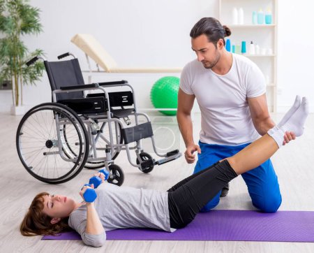 Foto de Mujer en silla de ruedas haciendo ejercicios deportivos con entrenador personal - Imagen libre de derechos