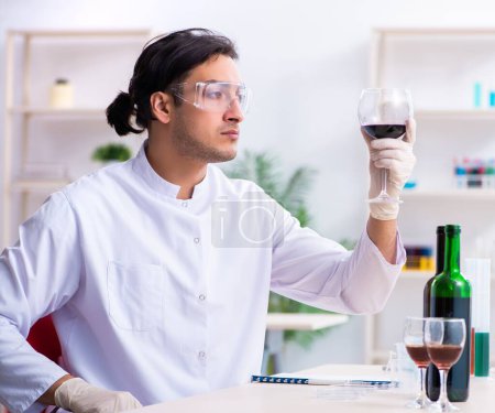 Photo for The male chemist examining wine samples at lab - Royalty Free Image