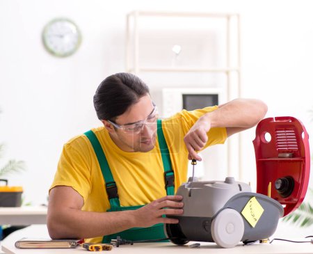 Photo for The man repairman repairing vacuum cleaner - Royalty Free Image