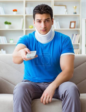 Foto de Hombre con lesión en el cuello viendo fútbol fútbol en casa - Imagen libre de derechos
