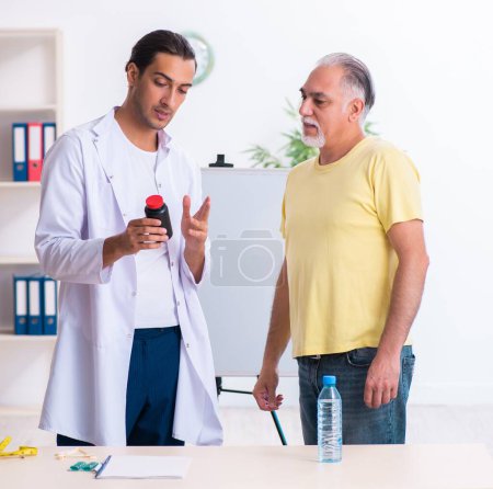 Foto de El médico dietista dando consejos al paciente con sobrepeso de grasa - Imagen libre de derechos