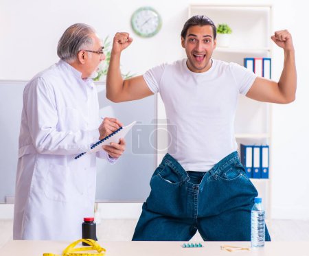 Téléchargez les photos : Le médecin diététicien et patient heureux portant un pantalon large - en image libre de droit