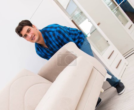 Téléchargez les photos : Le jeune homme déplaçant canapé canapé - en image libre de droit