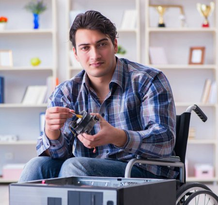 Photo for The disabled man on wheelchair repairing computer - Royalty Free Image