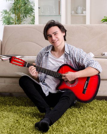Photo for The young man with guitar at home - Royalty Free Image