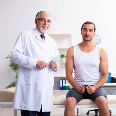 Téléchargez les photos : Le jeune patient de sexe masculin visite médecin expérimenté - en image libre de droit