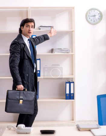 Téléchargez les photos : Le jeune employé masculin dans le bureau dans le concept de gestion du temps - en image libre de droit