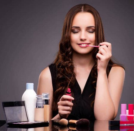Photo for The woman doing makeup on dark background - Royalty Free Image