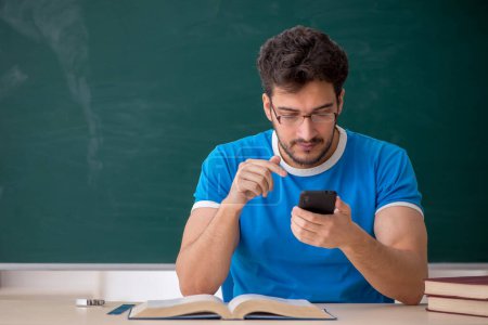 Foto de Joven estudiante sosteniendo smartphone en el aula - Imagen libre de derechos