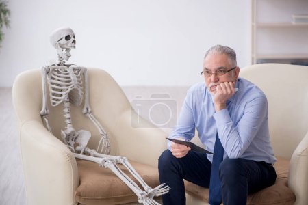 Photo for Old psychologist meeting with skeleton - Royalty Free Image