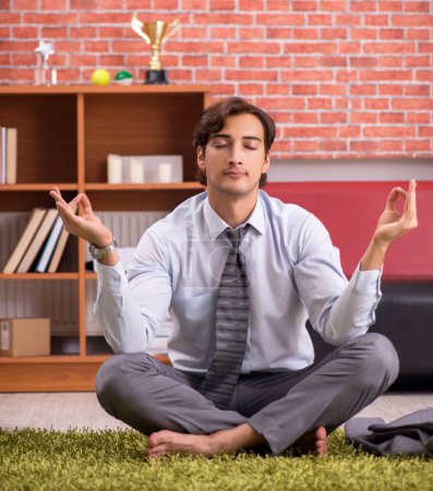 Photo for The young handsome employee doing yoga in the office - Royalty Free Image