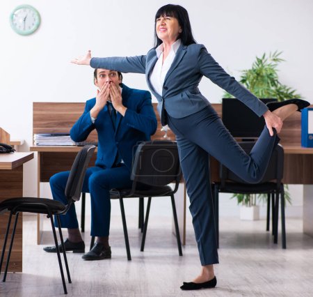 Téléchargez les photos : Les deux employés qui font des exercices sportifs au bureau - en image libre de droit