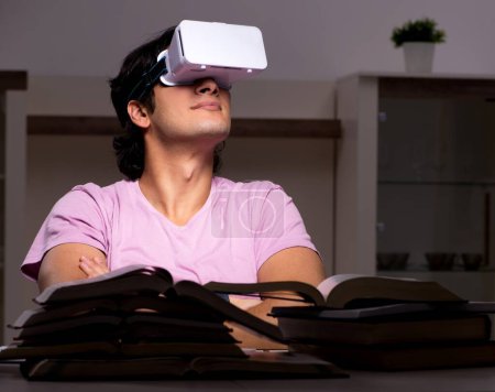 Téléchargez les photos : L'étudiant mâle avec des lunettes virtuelles tard à la maison - en image libre de droit