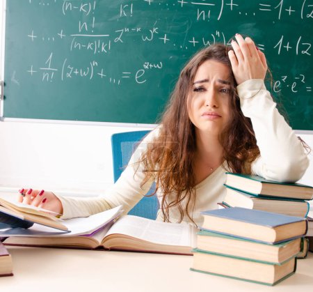 Foto de La joven profesora de matemáticas delante de la pizarra - Imagen libre de derechos