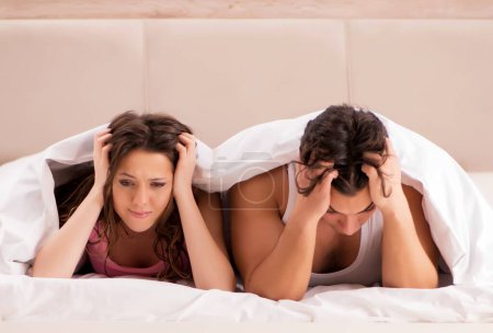 Foto de El conflicto familiar con la esposa marido en la cama - Imagen libre de derechos