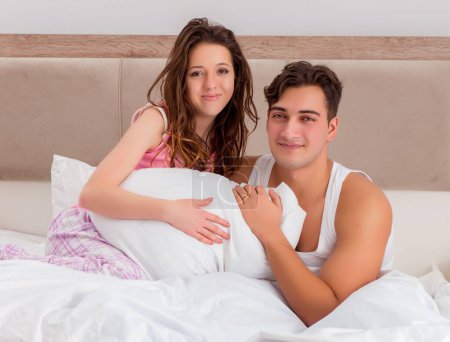 Foto de El concepto divertido con la esposa y el marido en la cama - Imagen libre de derechos