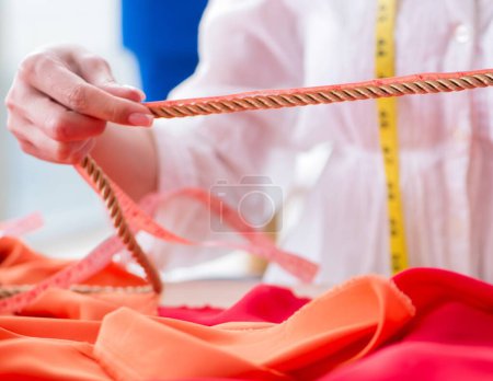 Téléchargez les photos : La femme tailleur travaillant sur de nouvelles conceptions de robe - en image libre de droit