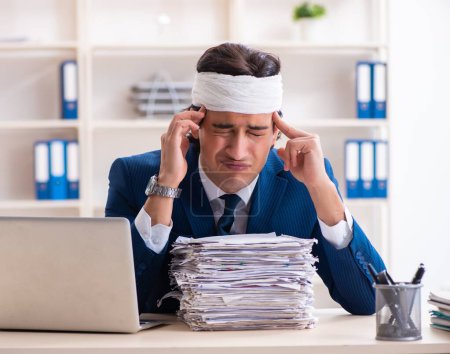 Photo for The head injured male employee working in the office - Royalty Free Image