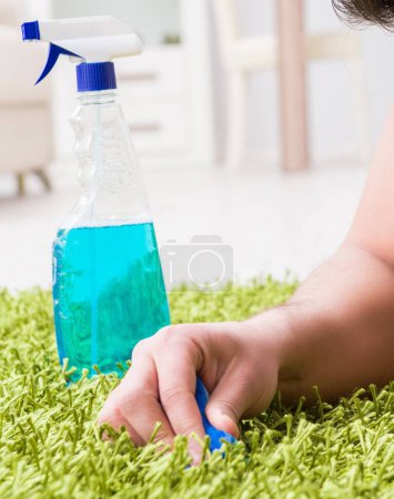 Téléchargez les photos : Le jeune mari homme nettoyage plancher à la maison - en image libre de droit