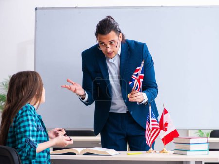 Téléchargez les photos : Le professeur d'anglais masculin et étudiante dans la salle de classe - en image libre de droit